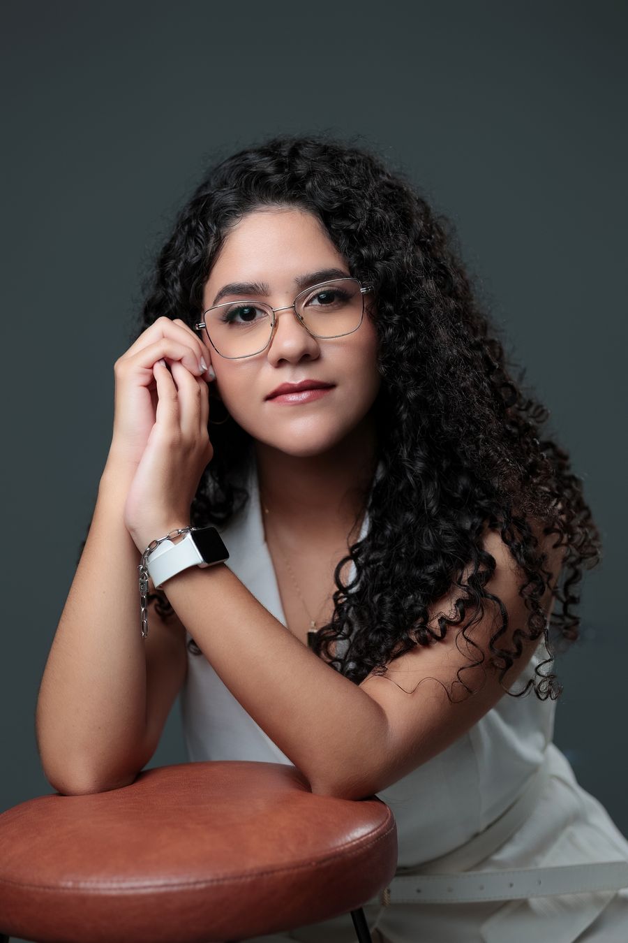 Retrato de Gabrielle Aquino, fonoaudióloga, sorrindo em ambiente de estúdio.