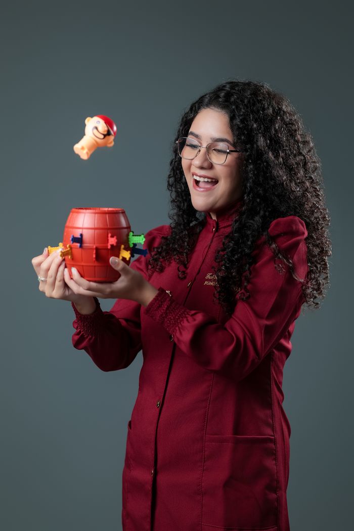 Gabrielle Aquino brincando com um brinquedo de encaixe colorido durante atividade lúdica de terapia.