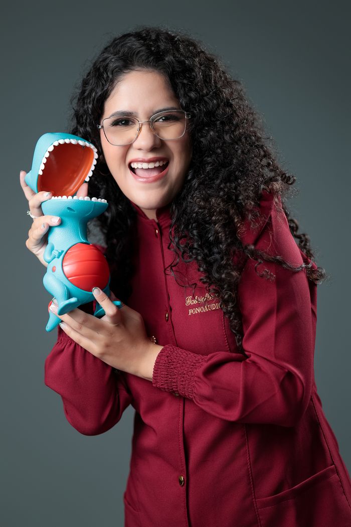 Gabrielle Aquino interagindo com um fantoche usado como recurso lúdico em sessão de terapia da linguagem.